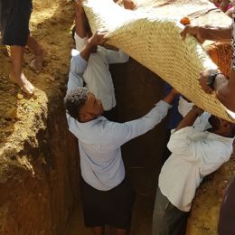 Placing mats in the grave