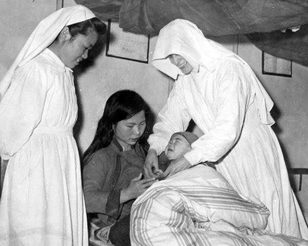 Two Sisters helping a mother with her baby in China